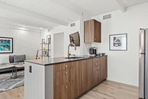 a kitchen with wooden cabinets and a living room at the Weekend Palm Springs in Palm Springs