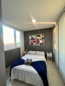 a bedroom with a large bed with blue sheets at BH com Vista Imbatível! in Belo Horizonte