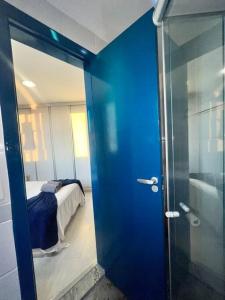 a blue door leading to a bedroom with a bed at BH com Vista Imbatível! in Belo Horizonte