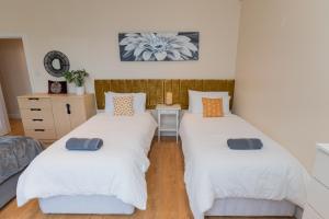 two twin beds in a room with a couch at Aston Apartments-4 11 Lichfield Road Birmingham B6 5RW in Birmingham