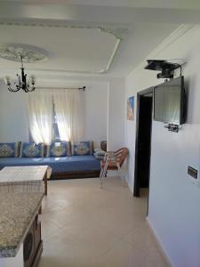- un salon avec un canapé bleu et une table dans l'établissement Apartment Corniche Ksar Sgher, à Ksar Sghir