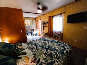 - une chambre avec un lit et une télévision dans l'établissement MOOREA - Tropical Nest, à Hauru