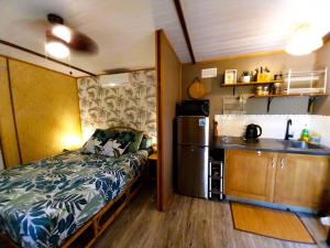 a small room with a bed and a kitchen at MOOREA - Tropical Nest in Hauru