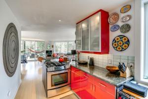 a kitchen with red cabinets and a counter top at Contemporary Elka Park Retreat with Views and Deck! in Elka Park