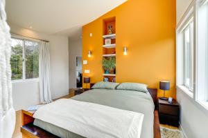 a bedroom with an orange accent wall and a bed at Contemporary Elka Park Retreat with Views and Deck! in Elka Park