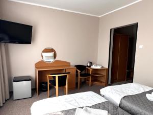 a hotel room with a bed and a desk with a mirror at KARAT in Malbork
