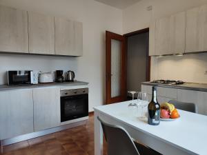 a kitchen with a white table with a bottle of wine at CASA DEL SOLE in Tremezzo