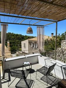 a patio with two chairs and a table and a bench at Terra del Nonno in Drymon
