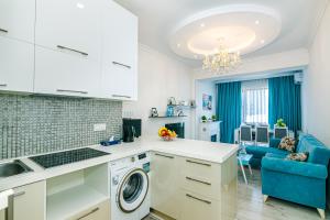 uma cozinha e sala de estar com máquina de lavar e secar roupa em Park azure sweet apartment by Baku Housing em Baku