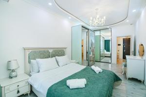 um quarto com uma cama grande com duas toalhas em Park azure sweet apartment by Baku Housing em Baku