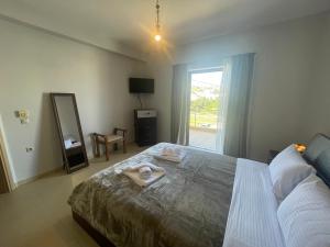 Schlafzimmer mit einem Bett, einem Spiegel und einem Fenster in der Unterkunft Villa Melydron in Nafplio