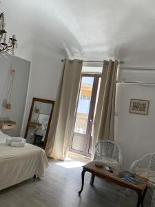 a bedroom with a bed and a window and a table at Sicilianamente Stay in Catania