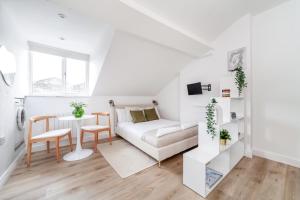 a white living room with a couch and a table at Arte Stays Serviced Apartments Premium Studios, Finsbury Park in London