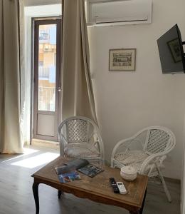 a living room with a coffee table and two chairs at Sicilianamente Stay in Catania
