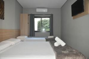 una camera da letto con due letti e una finestra di Unity Hotel - Paulista - SP a San Paolo