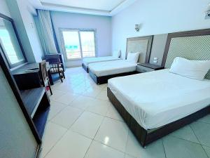 洪加達的住宿－Cecelia Hotel Suites Hurghada，酒店客房设有两张床和一张桌子。
