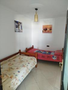 two beds are in a room with at Apartment Corniche Ksar Sgher in Ksar es Sghir