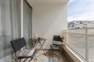 d'un balcon avec deux chaises, une table et une fenêtre. dans l'établissement Apartment L&I, à Šibenik