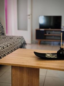 a wooden coffee table in a living room with a television at Sunlight apartment in Néa Péramos