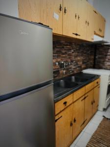a kitchen with a stainless steel refrigerator and a sink at Sunlight apartment in Nea Peramos