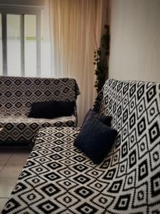 a couch with two pillows on it in a room at Sunlight apartment in Nea Peramos