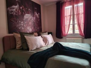 a bedroom with a large bed with red curtains at T2 54m² parking Cœur de Chartres in Chartres +18 photos