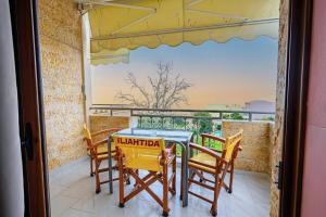 een tafel en stoelen op een balkon met uitzicht bij Iliahtida Apartments in Rovies