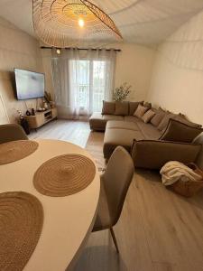 ein Wohnzimmer mit einem Sofa und einem Tisch in der Unterkunft Appartement spacieux 6 personnes in Magny-les-Hameaux
