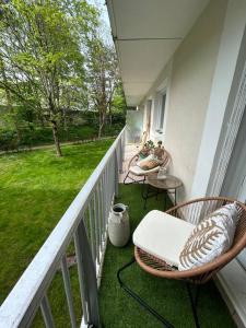 einen Balkon mit einem Stuhl, einem Tisch und einem Hof in der Unterkunft Appartement spacieux 6 personnes in Magny-les-Hameaux