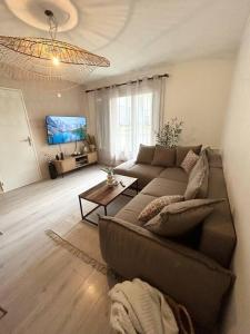 ein Wohnzimmer mit einem Sofa und einem TV in der Unterkunft Appartement spacieux 6 personnes in Magny-les-Hameaux