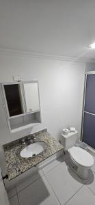 a bathroom with a sink and a toilet and a mirror at LEON MARIA HOSPEDAGENS - Smart Flat Hotel e Residence in Mogi das Cruzes