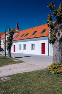 un edificio blanco con techo naranja y puertas rojas en Apartmán U Zámku - Apartment by the Castle, en Strakonice
