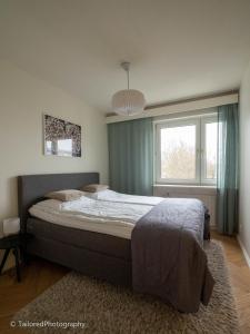 Un dormitorio con una cama grande y una ventana en Studiohuoneisto Ainonkatu AC, WiFi, balcony en Lappeenranta