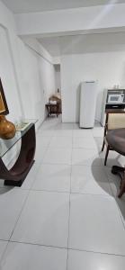 a living room with white floors and a refrigerator at LEON MARIA HOSPEDAGENS - Smart Flat Hotel e Residence in Mogi das Cruzes