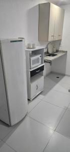 a kitchen with a refrigerator and a microwave at LEON MARIA HOSPEDAGENS - Smart Flat Hotel e Residence in Mogi das Cruzes