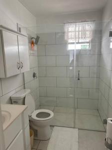 La salle de bains blanche est pourvue d'une douche et de toilettes. dans l'établissement Ottie-Newly Renovated, 5 min from beach, à Saint James