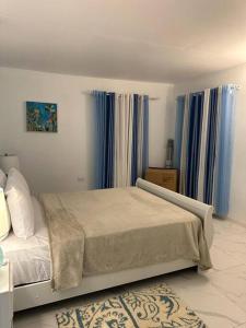 - une chambre avec un grand lit et des rideaux bleus dans l'établissement Ottie-Newly Renovated, 5 min from beach, à Saint James