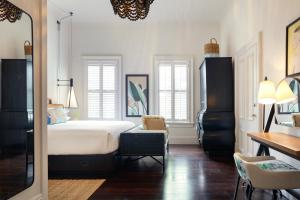 1 dormitorio con cama, escritorio y silla en Ridley House - Key West Historic Inns, en Key West