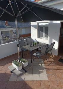 a table and chairs under an umbrella on a patio at Apartment Martina in Rab