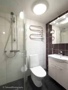 a bathroom with a toilet and a sink and a shower at Studiohuoneisto Ainonkatu AC, WiFi, balcony in Lappeenranta