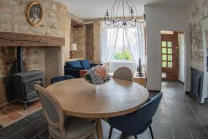 a dining room with a table with chairs and a fireplace at Les Gîtes de la Vallée du Céou in Gourdon-en-quercy