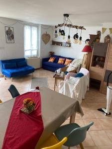 un soggiorno con un tavolo e un divano blu di Studio Les trois Maries Fondettes Proche Tours a Fondettes