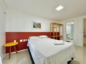 a bedroom with a large bed and a yellow table at Solarium Residence no Porto das Dunas in Aquiraz +188 photos