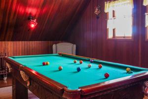una mesa de billar con pelotas en una habitación en Guest House Família, en Campos do Jordão