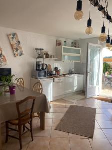 uma cozinha com uma mesa e cadeiras e uma mesa e uma cozinha em Gîte des trois Marie Studio 40m2 Fondettes Tours em Fondettes