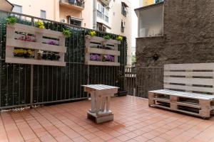 拿坡里的住宿－Benincasa Rooms Napoli，庭院设有长凳和围栏上的鲜花