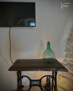 un vase en verre vert assis sur une table en bois dans l'établissement Trullo Galileo, à Alberobello