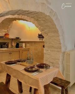 - une table dans une cuisine avec une arche en pierre dans l'établissement Trullo Galileo, à Alberobello