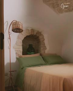 - une chambre avec un lit et un mur en pierre dans l'établissement Trullo Galileo, à Alberobello