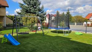 a playground with two swings on a lawn at Comfort Apartments Oświęcim in Oświęcim